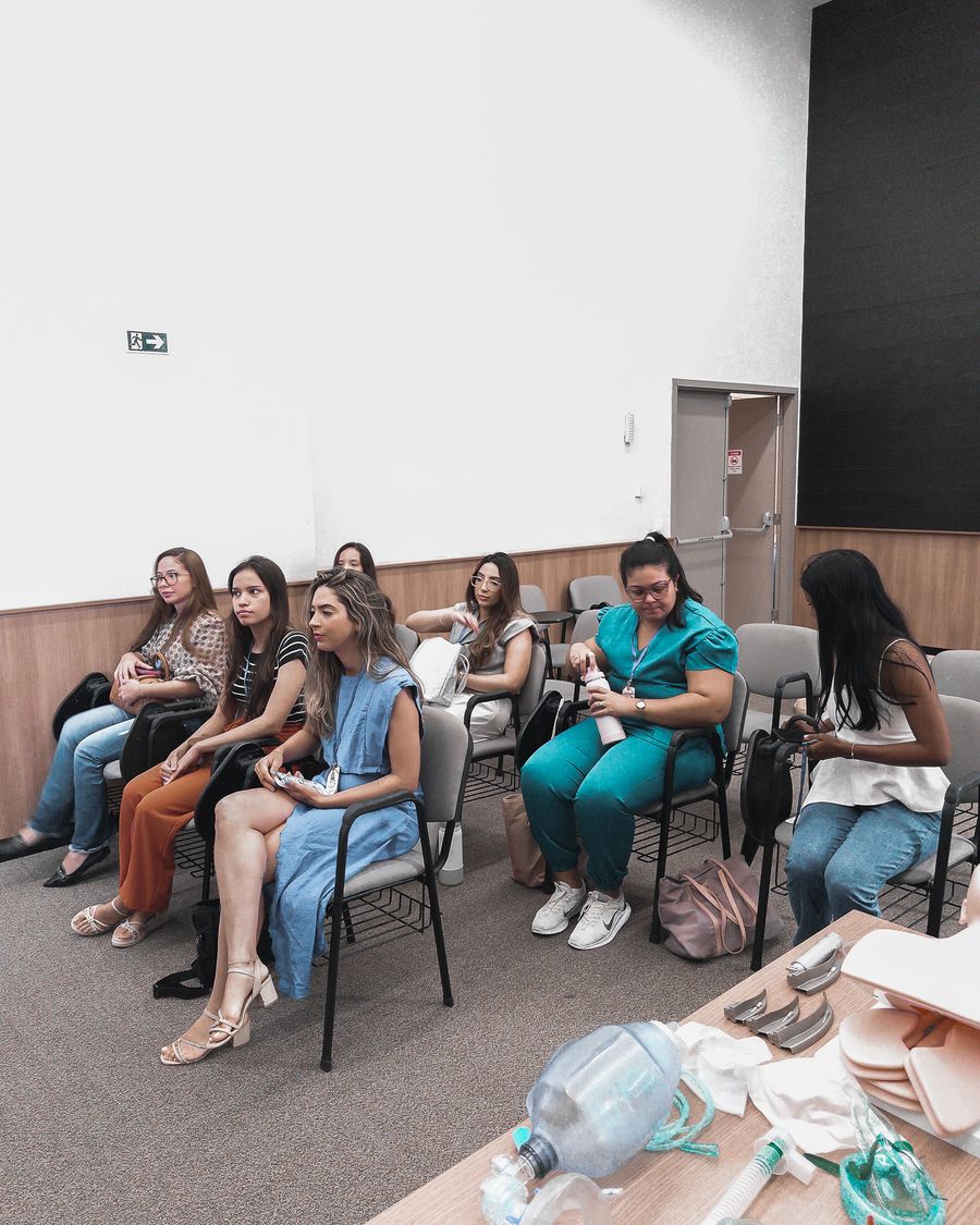 Turma reduzida em aula prática com materiais de simulação em primeiro plano